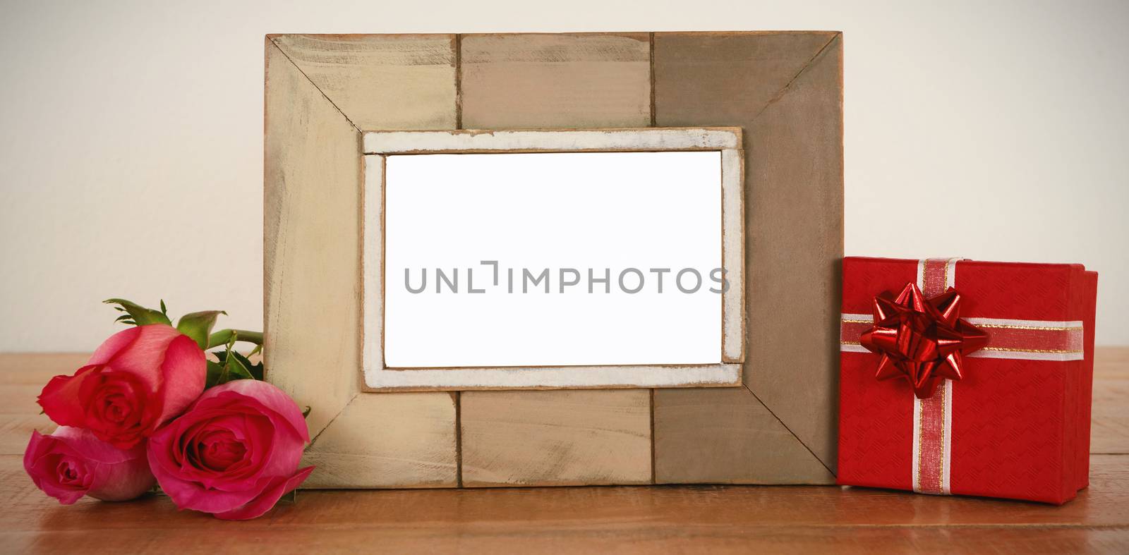 Photo frame, rose flower and gift boxes on a table by Wavebreakmedia