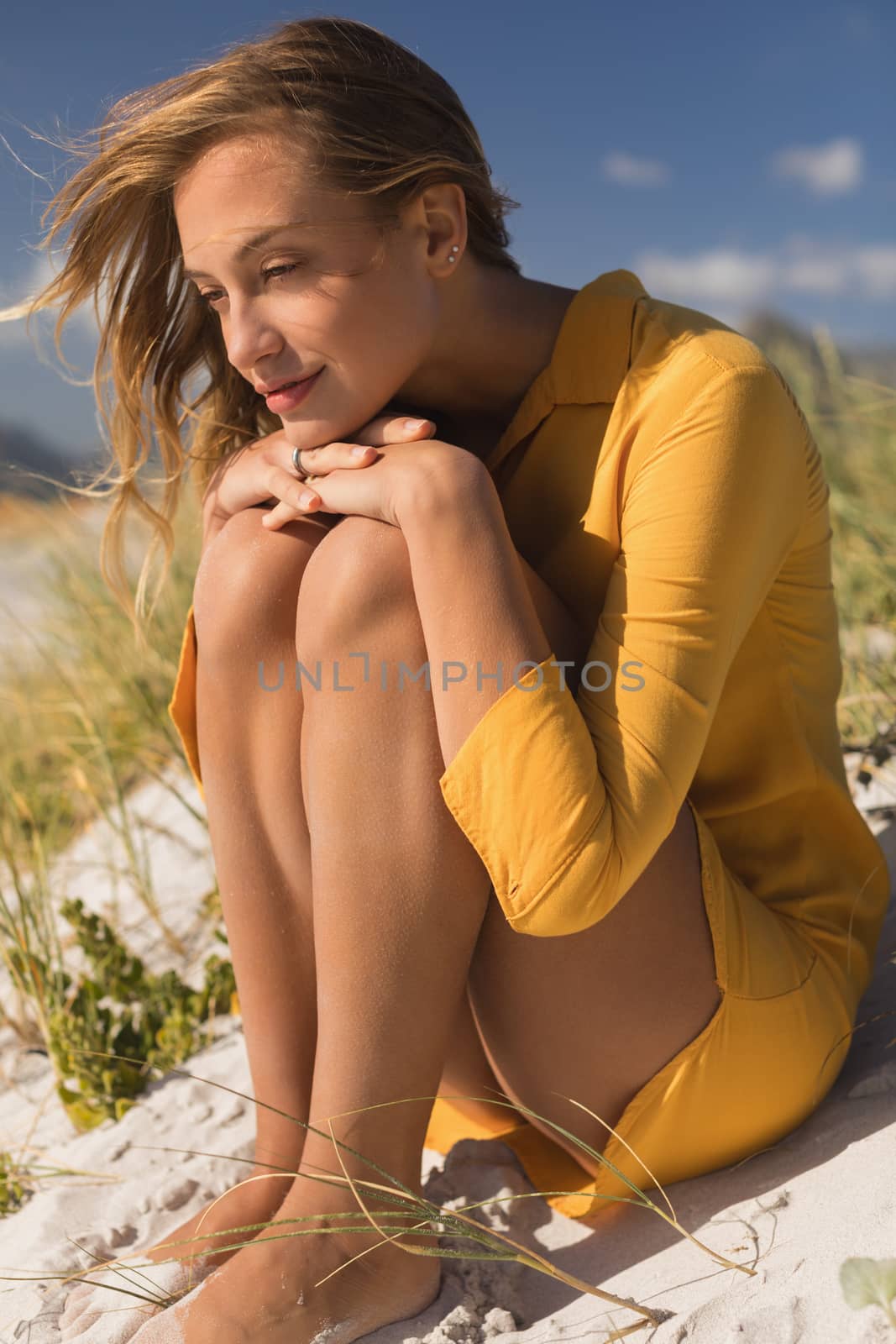 Side view of young woman relaxing on the beach on a sunny day