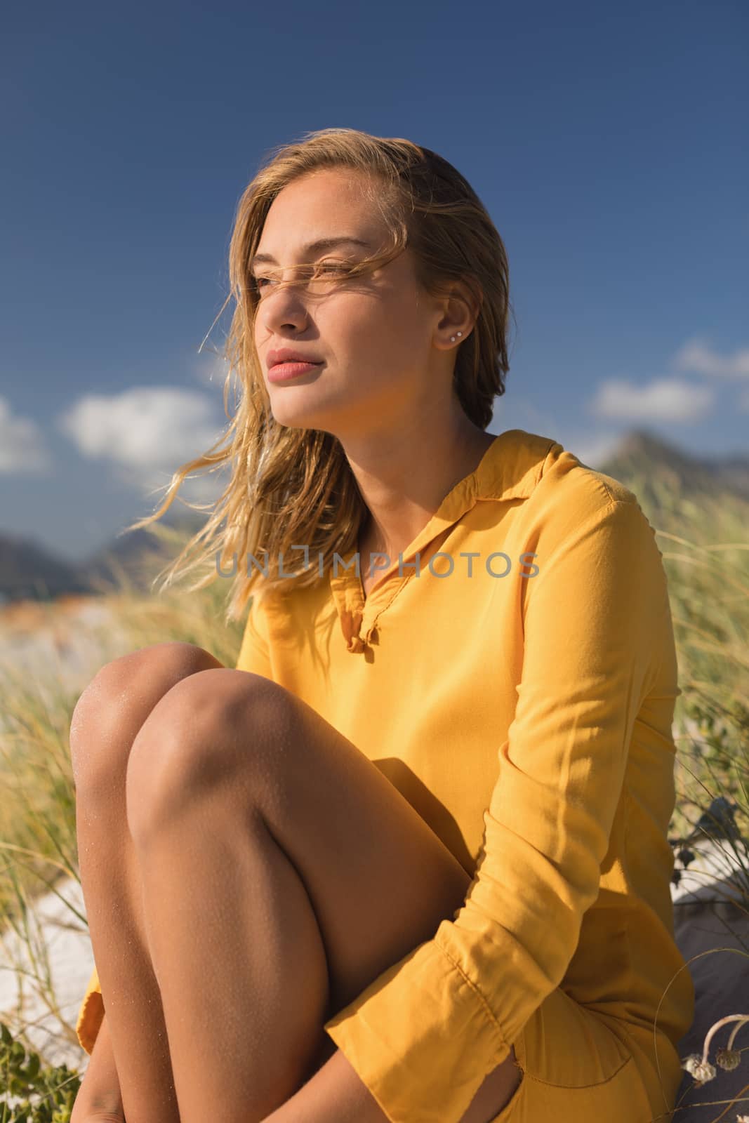 Side view of young woman relaxing on the beach on a sunny day