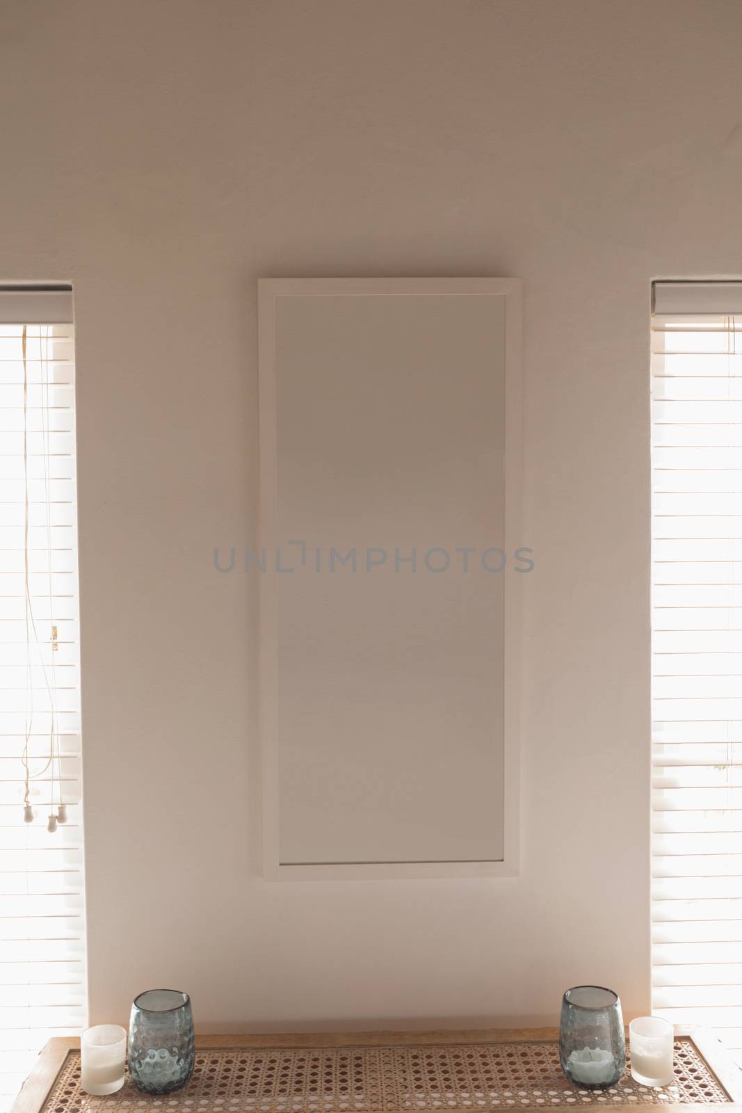 Modern wall frame fixed on the wall between two lamps at home