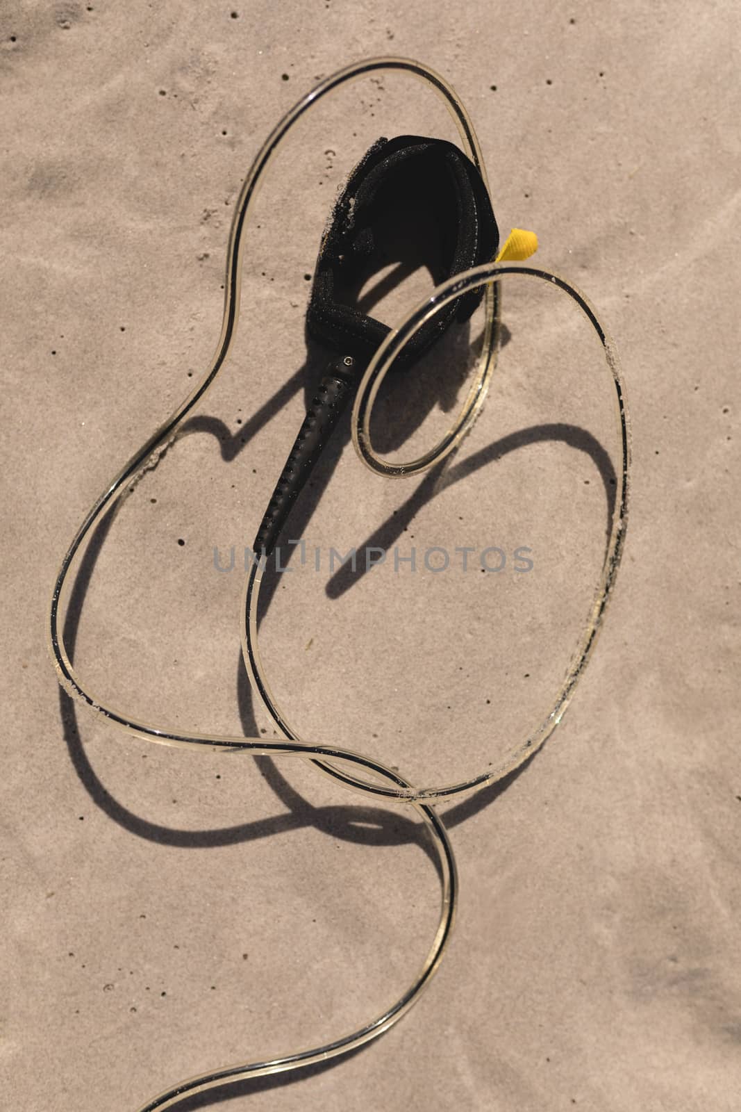 Close-up of surfboard leash on beach in the sunshine