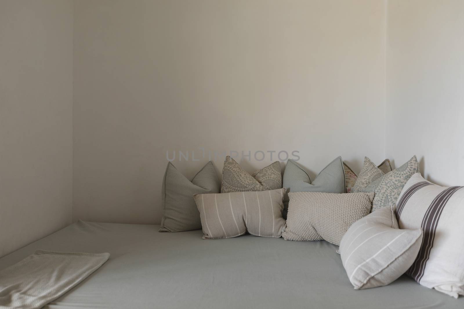 Front view of lots of pillows arranged on a bed in bedroom at home