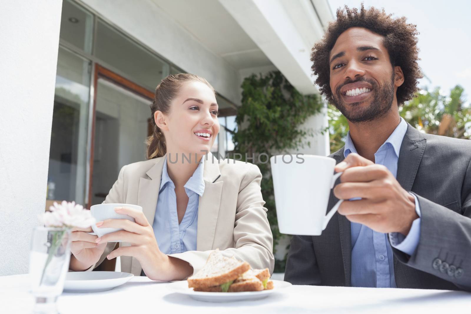 Happy business people on their lunch outside at the coffee shop