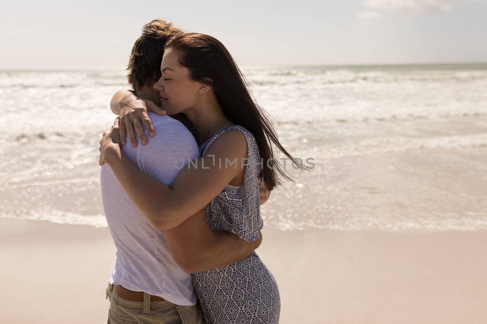 Romantic young couple embracing each other on beach by Wavebreakmedia