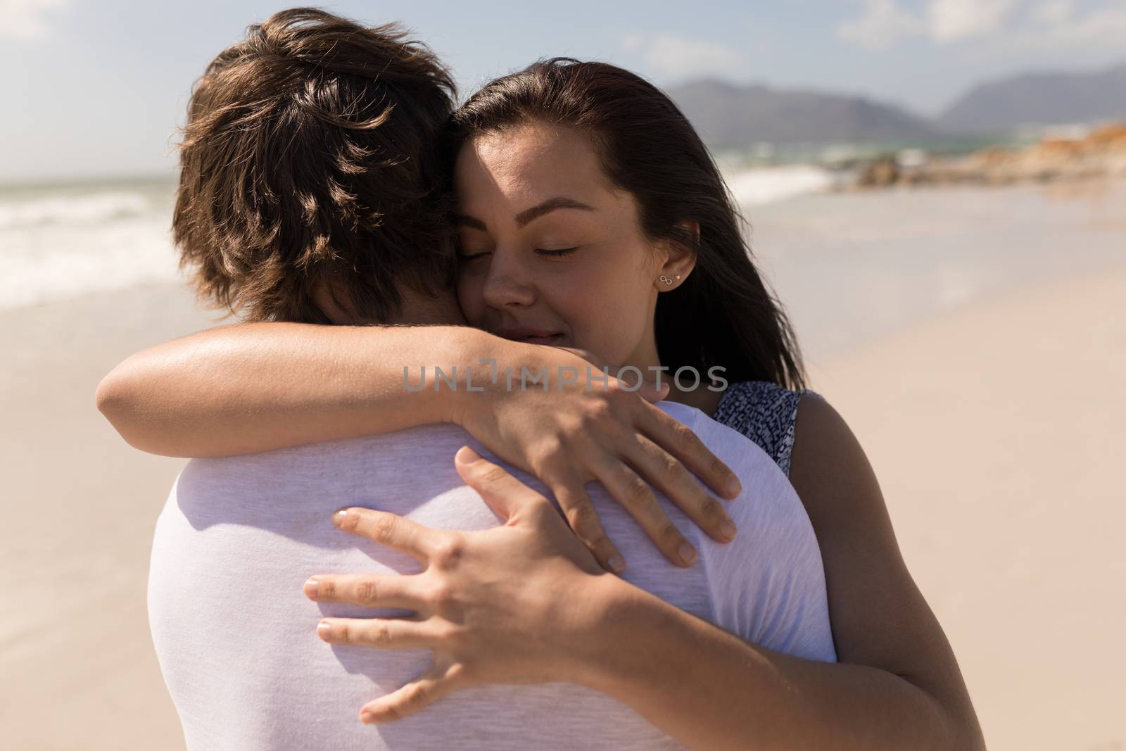 Romantic young couple embracing each other on beach by Wavebreakmedia