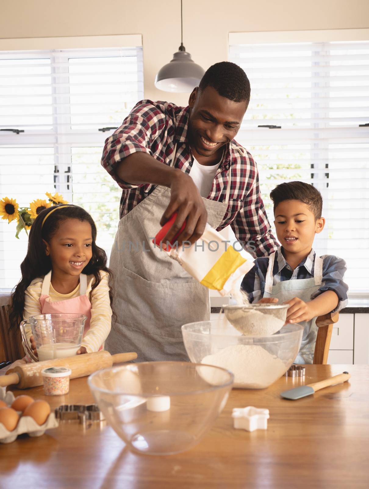 African American father and children baking cookies in kitchen  by Wavebreakmedia