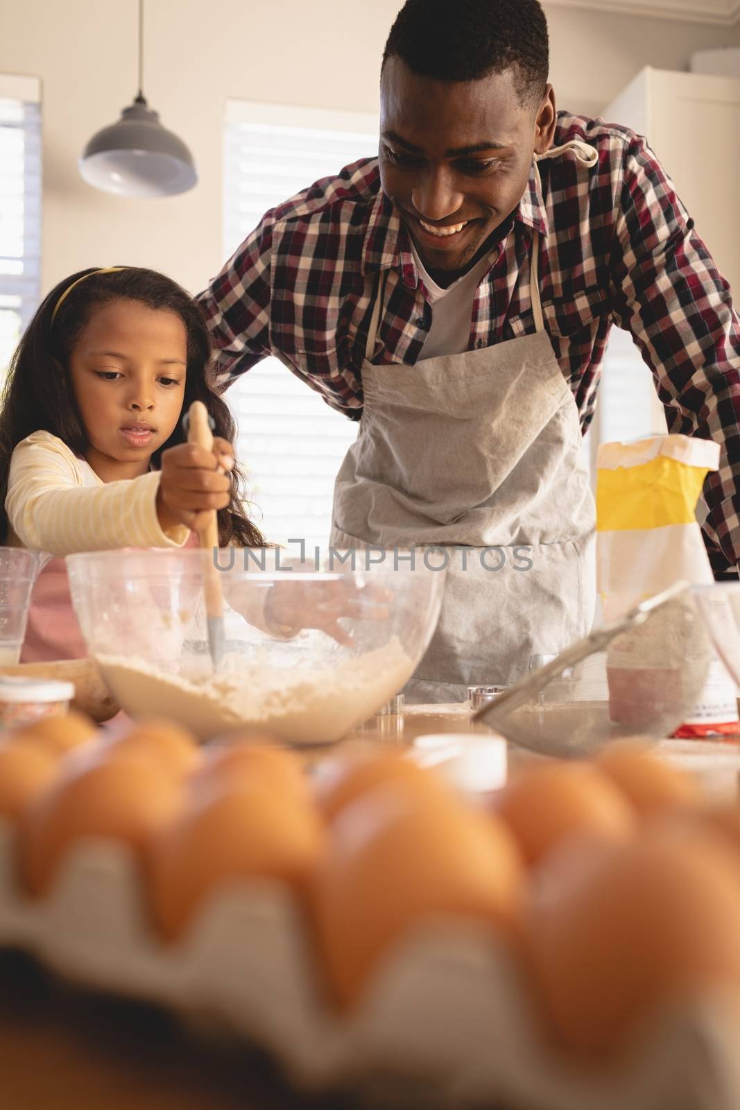 African American father and daughter baking cookies in kitchen by Wavebreakmedia