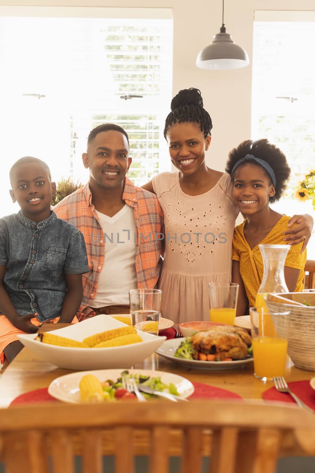 Happy African American family looking at camera on dining table by Wavebreakmedia