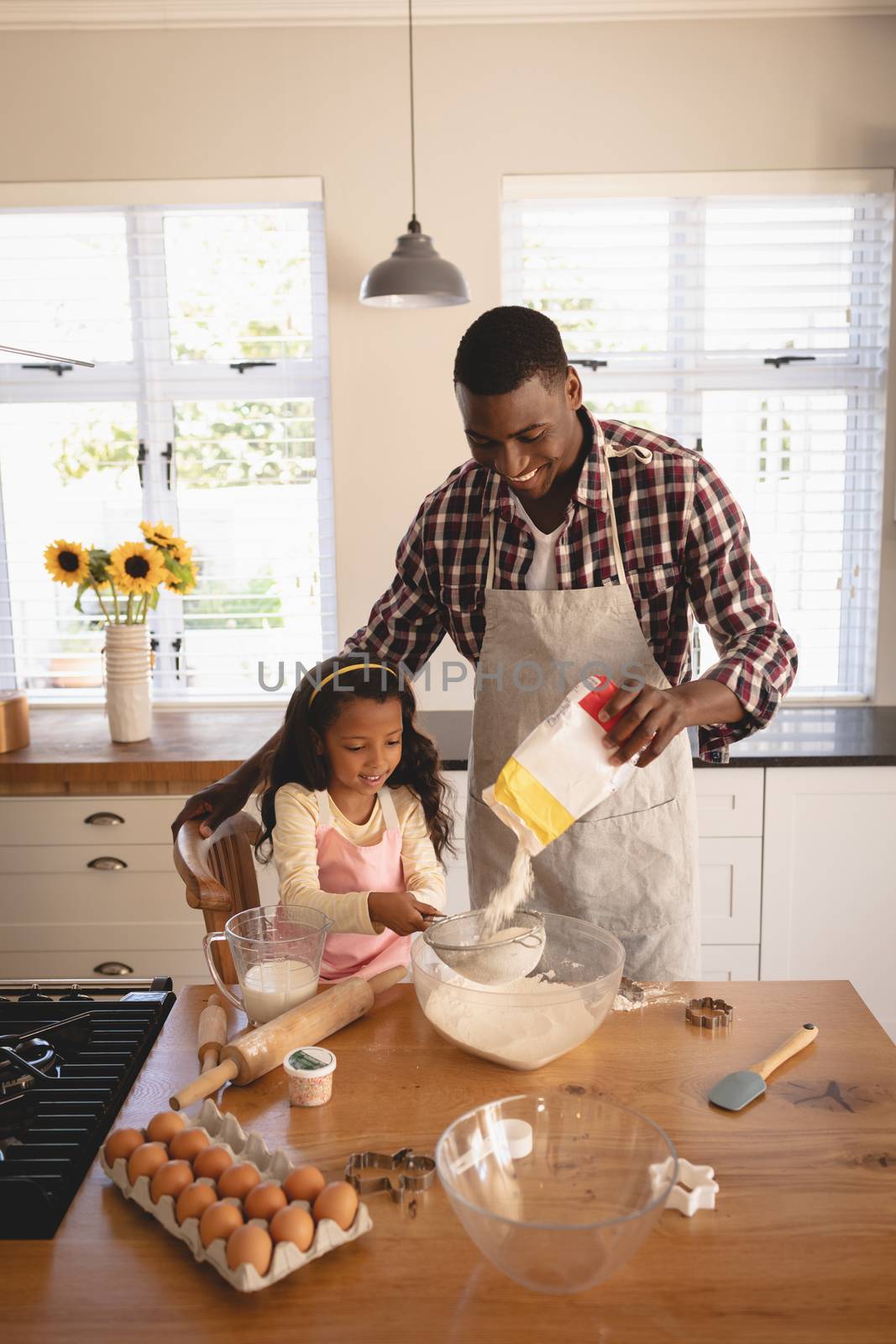 High angle view of African American father and daughter baking cookies in kitchen at home