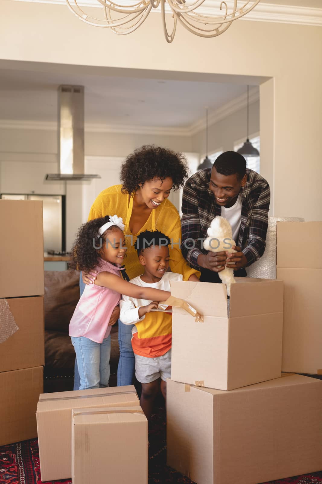 Happy African American parents with their children packing their belongings in living room by Wavebreakmedia