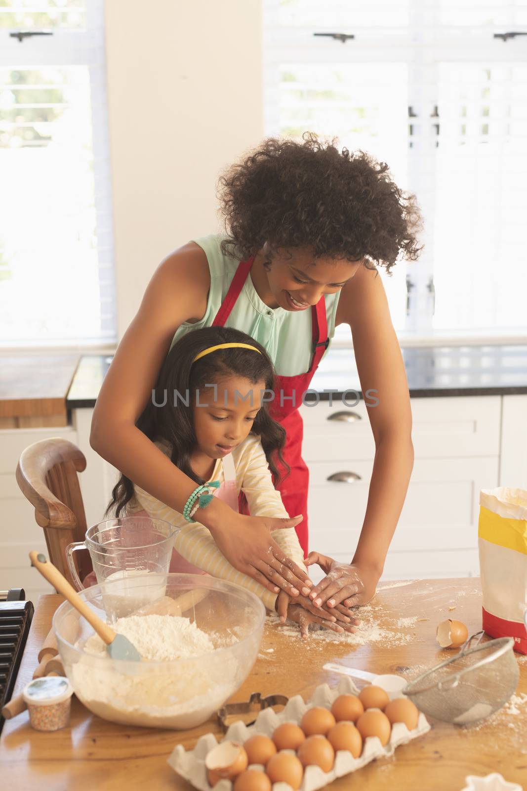 African American mother and daughter kneading cookie dough in kitchen by Wavebreakmedia