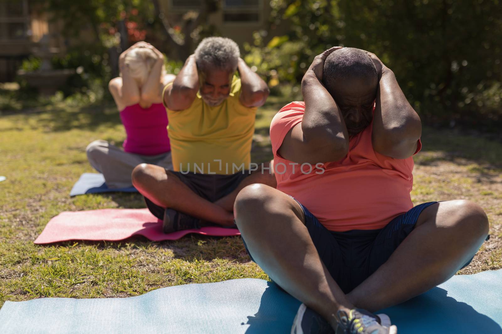 Senior people performing yoga in the park by Wavebreakmedia