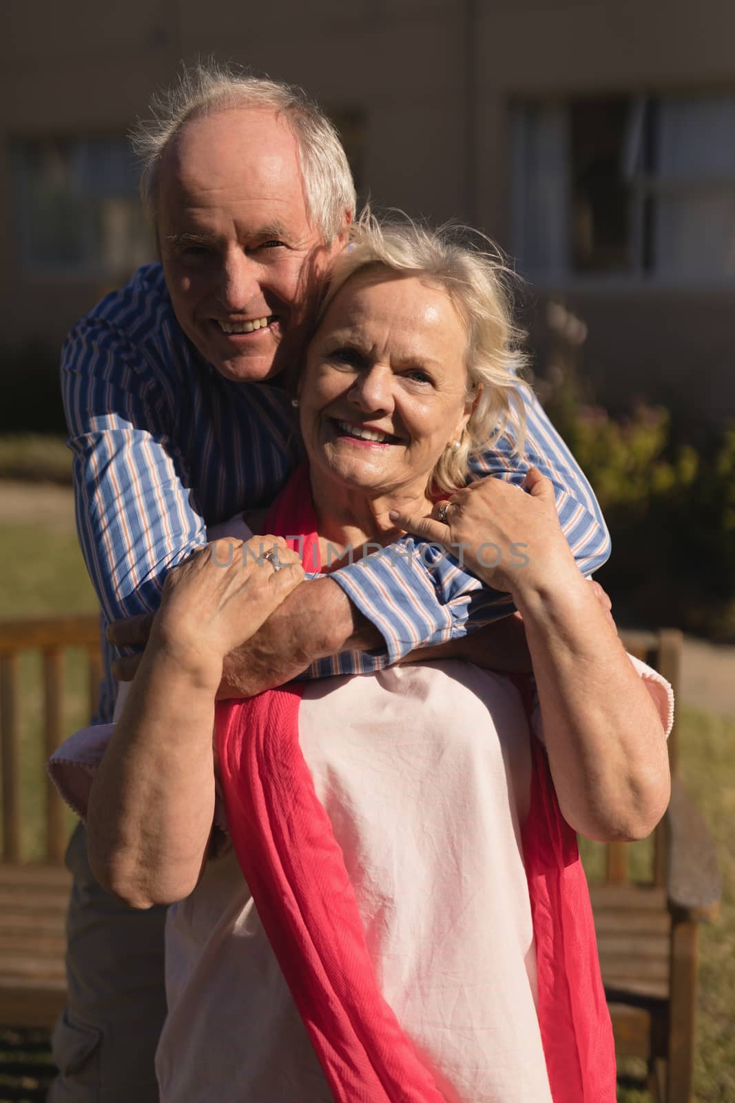 Portrait of active senior Caucasian couple embracing each other in the park