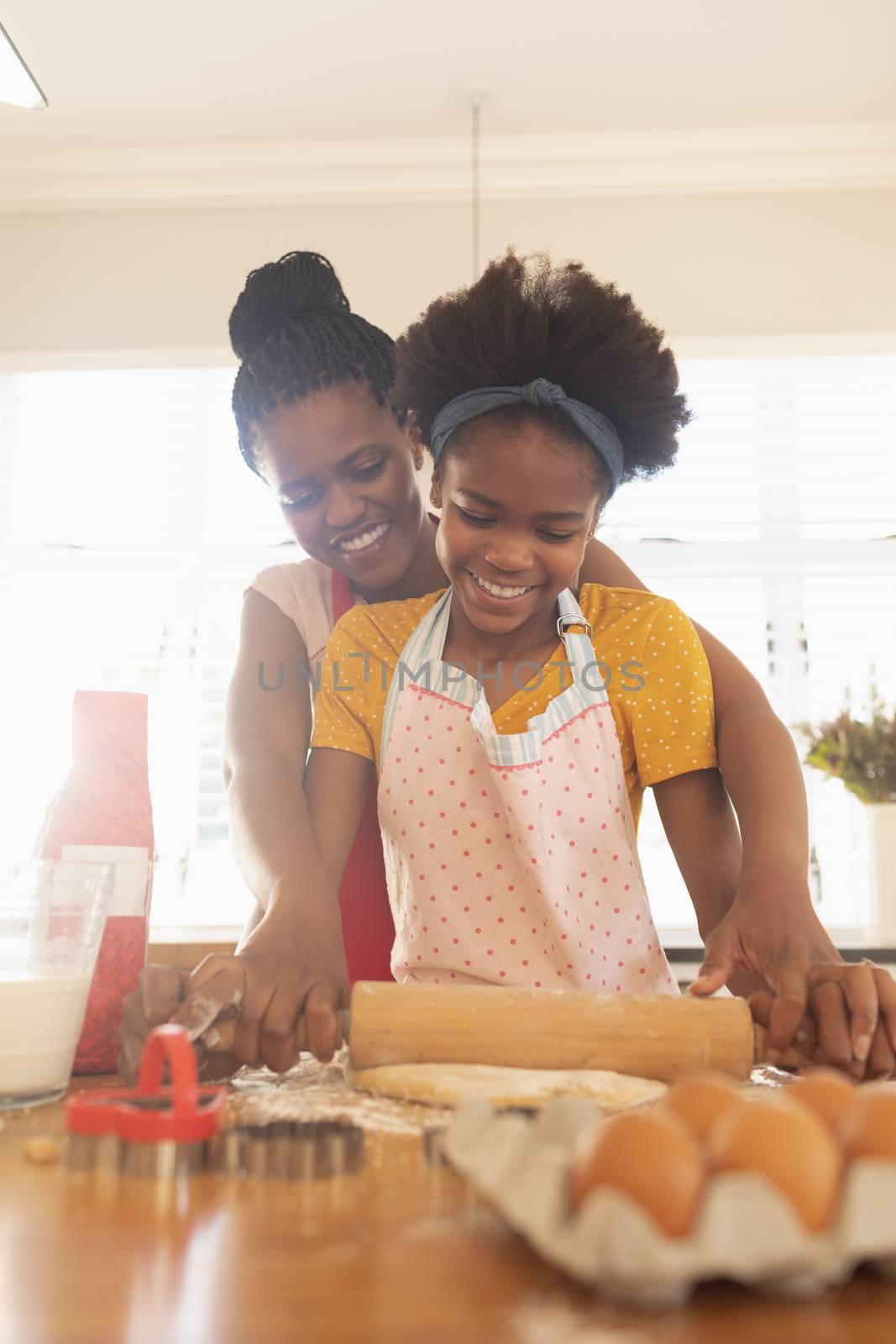 Low angle view of African American mother and daughter baking cookies in kitchen at home