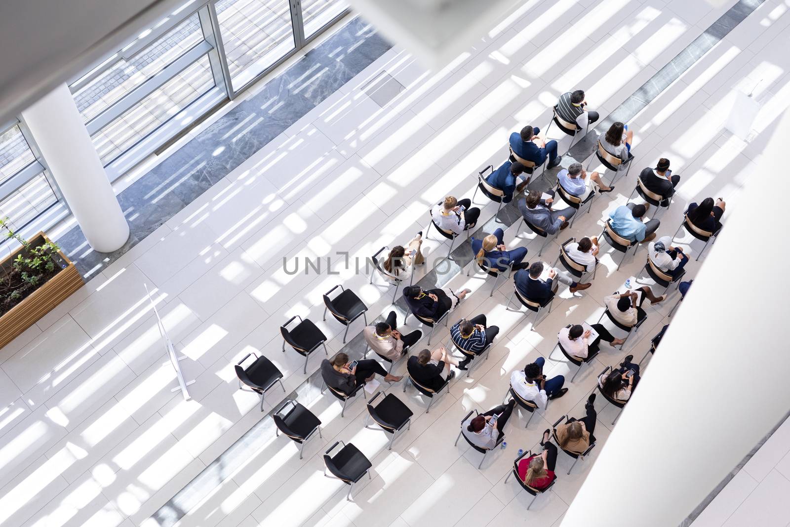 Multi-ethnic group of business people sitting on chair in lobby by Wavebreakmedia