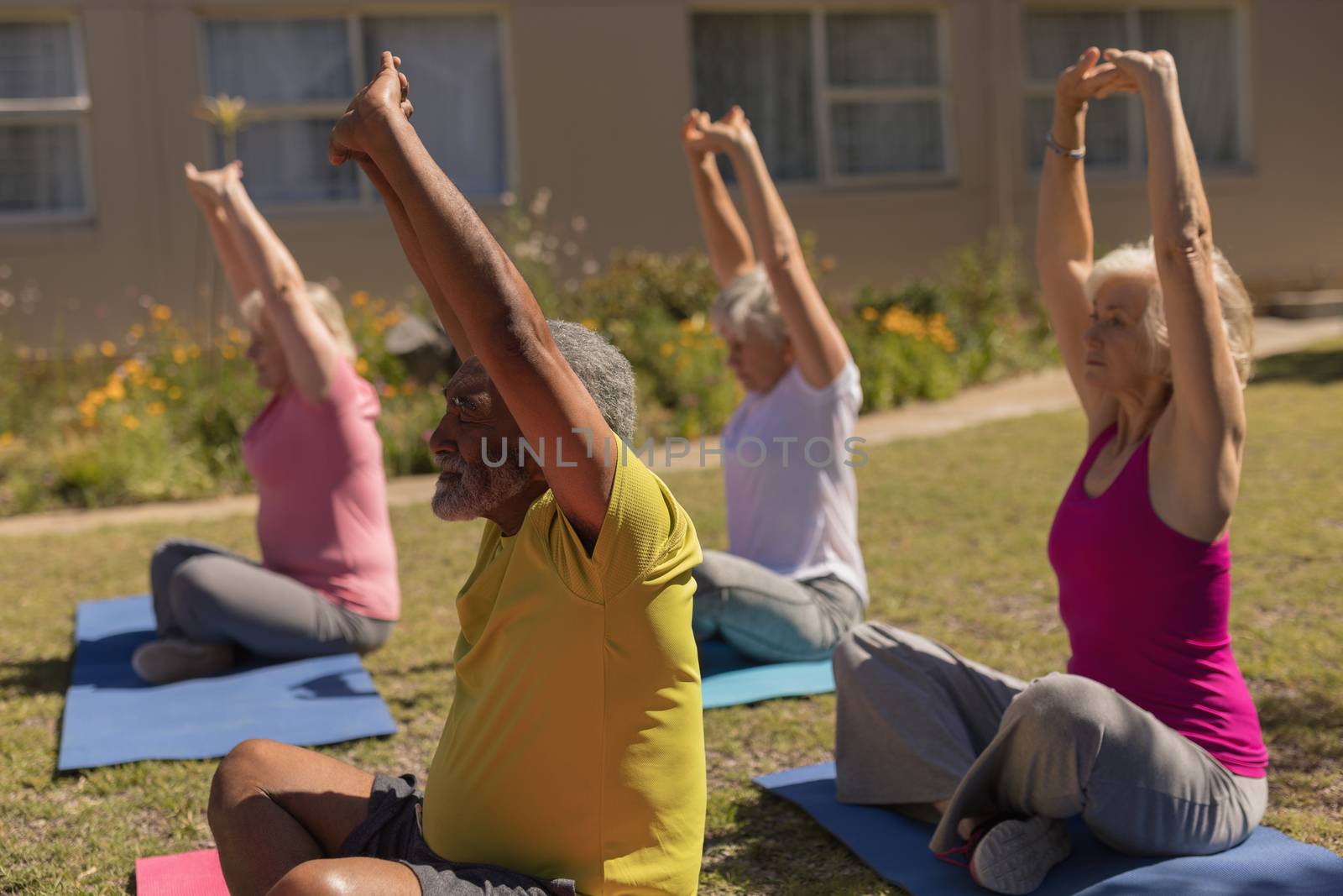 Senior people performing yoga in the park by Wavebreakmedia