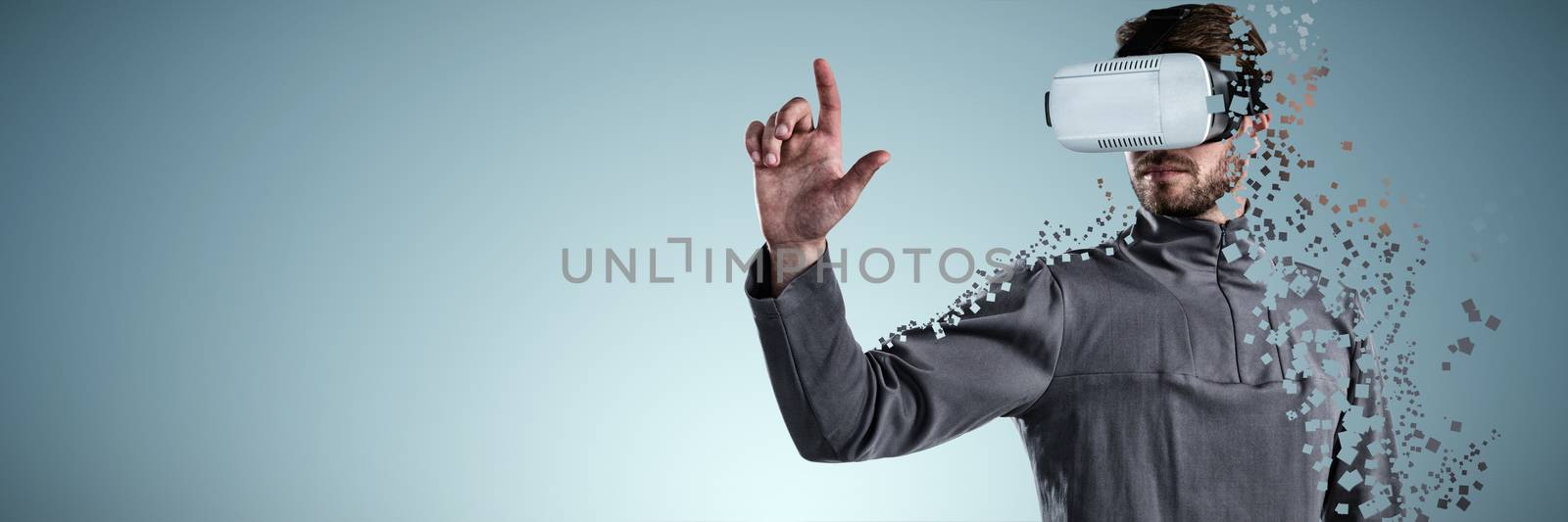 Man gesturing while using virtual reality headset against abstract grey background