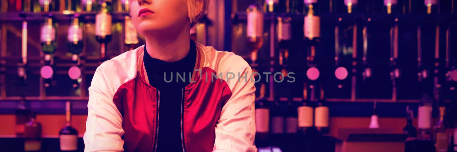 Thoughtful female bartender standing at bar counter