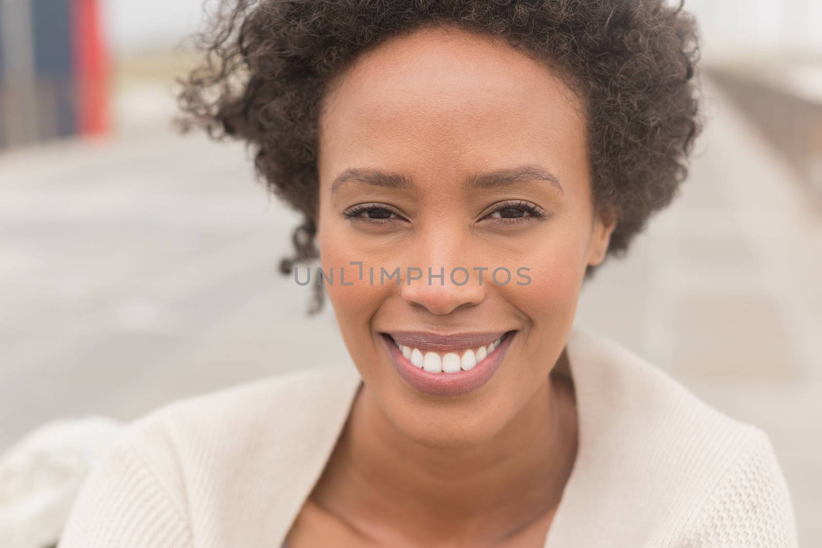 Portrait of happy young African American woman looking at camera. She is smiling