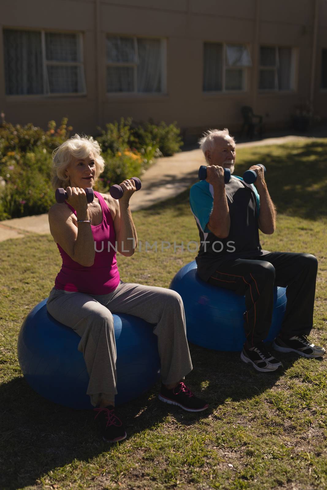 Senior couple exercising with dumbbells in the park by Wavebreakmedia