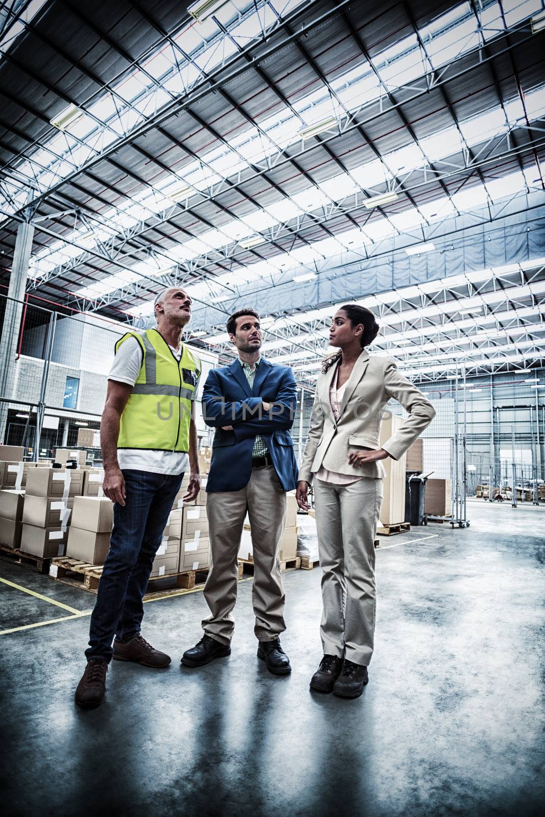 Warehouse managers discussing with the worker by Wavebreakmedia