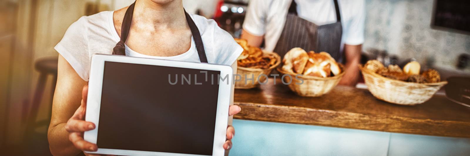 Portrait of woman holding digital tablet at baker shop