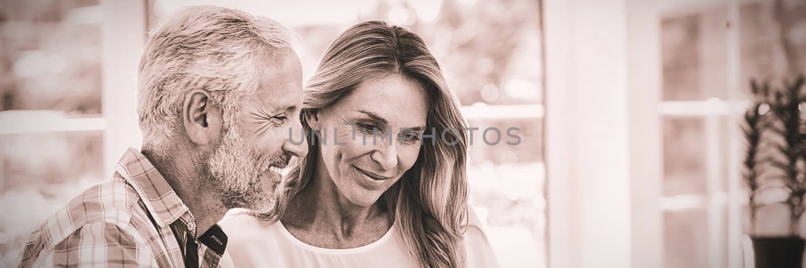 Couple looking in laptop on table by Wavebreakmedia