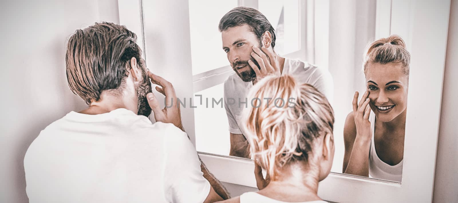 Couple checking their skin in bathroom at home
