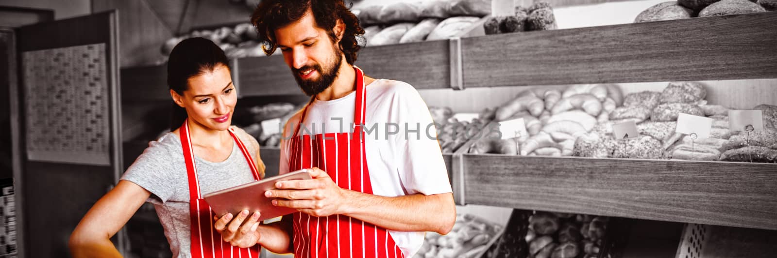 Couple using digital tablet in bakery shop