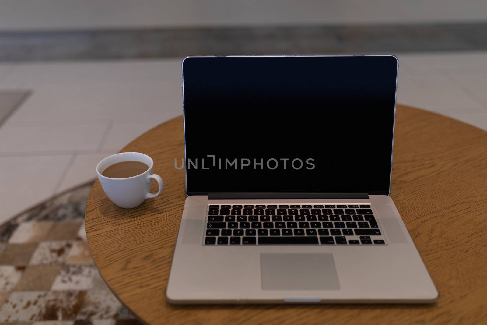 Laptop and cup of tea on a table in the lobby at office