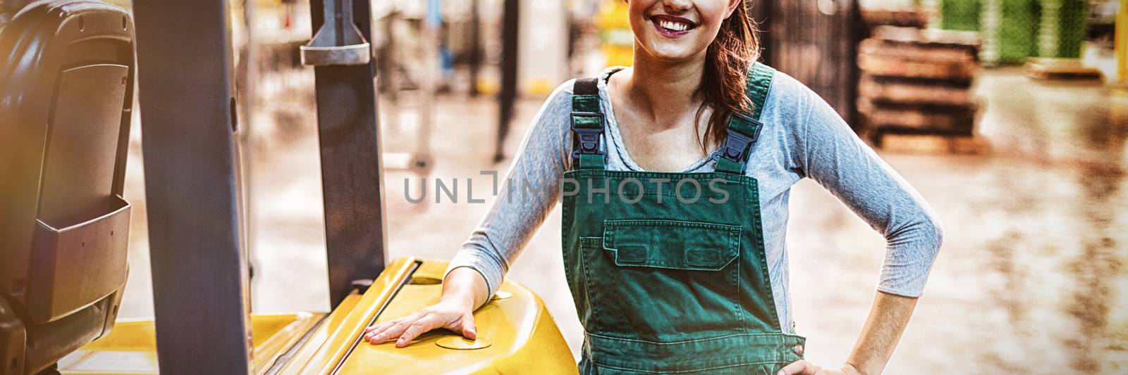 Portrait of female factory worker standing at drinks production factory