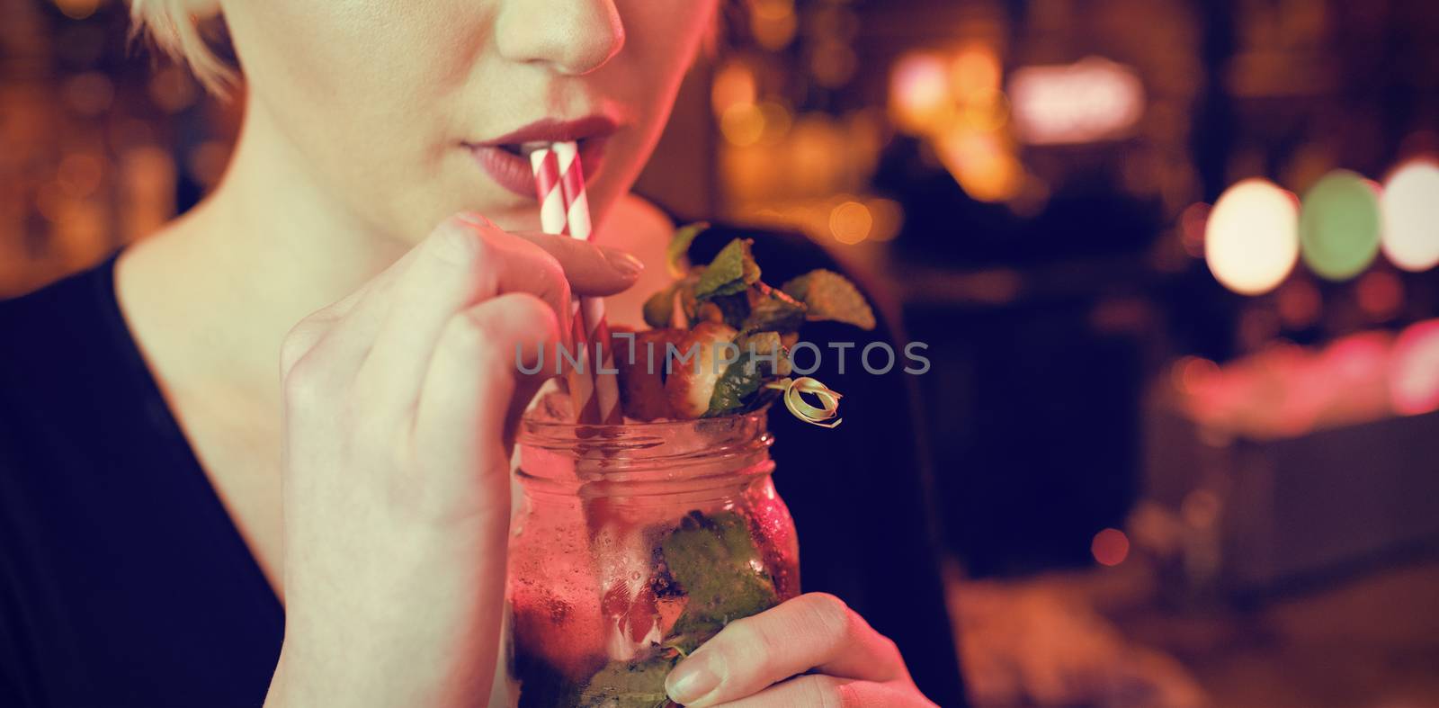 Portrait of beautiful woman having cocktail in bar