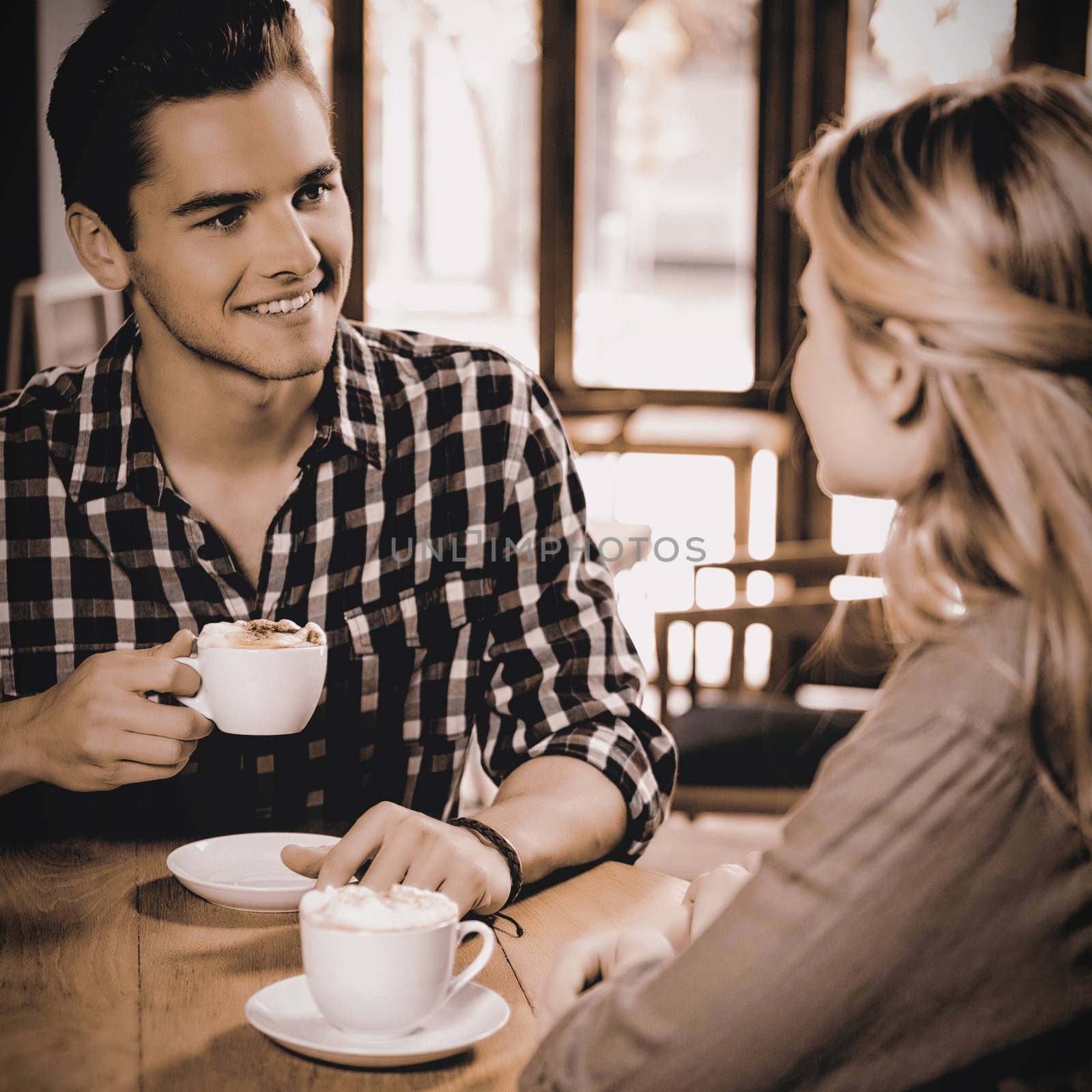 Man having coffee while talking with woman in cafe by Wavebreakmedia