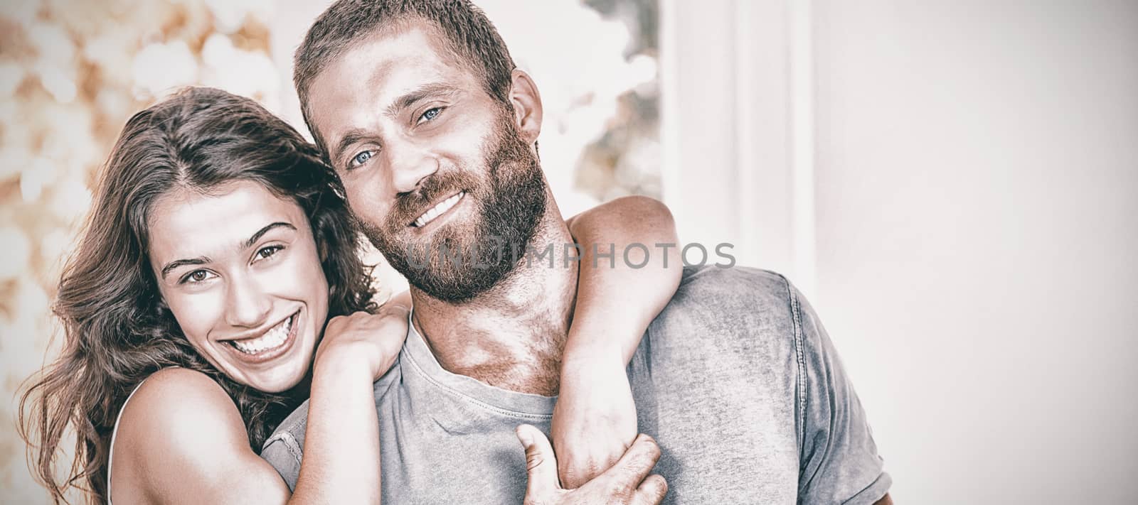 Portrait of young couple embracing at home