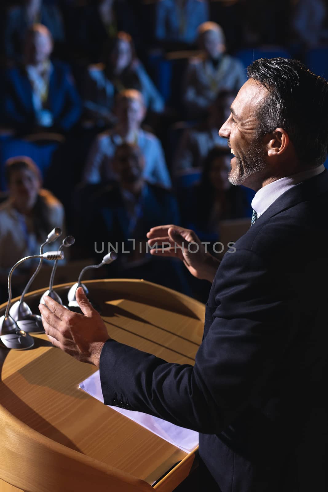 Businessman standing and giving presentation in the auditorium  by Wavebreakmedia