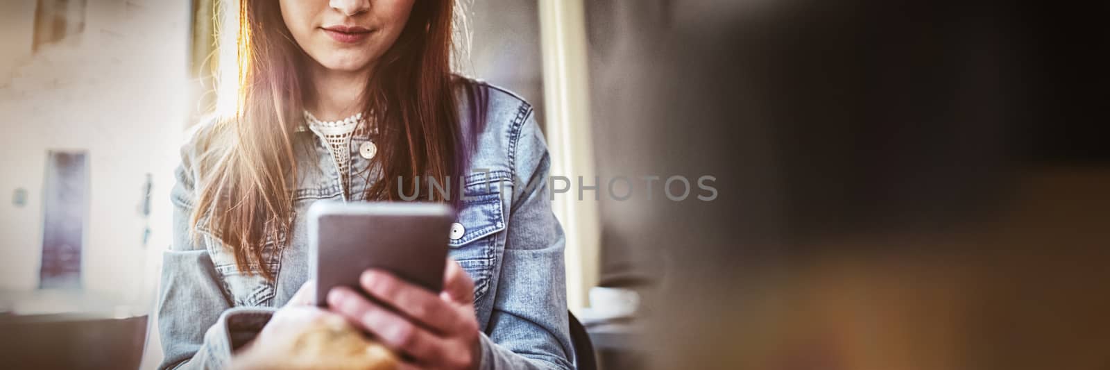 Beautiful young woman using smartphone at coffee shop