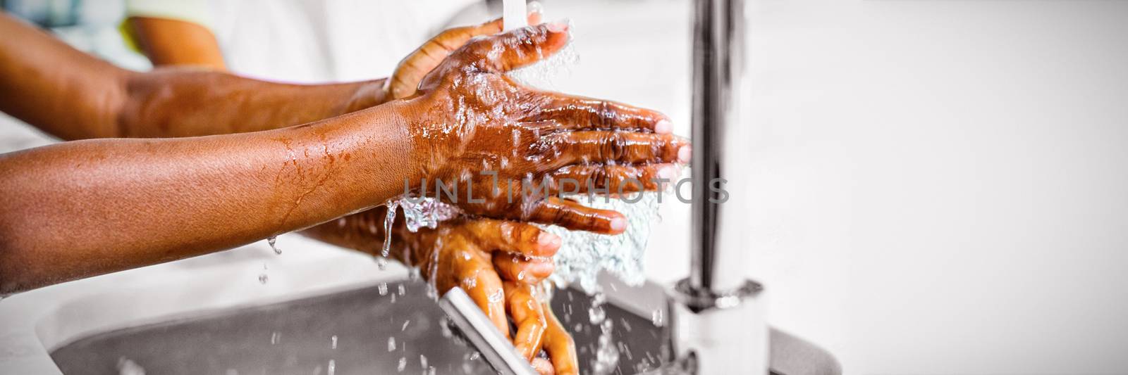 Smiling siblings washing hand in kitchen at home, Close-up