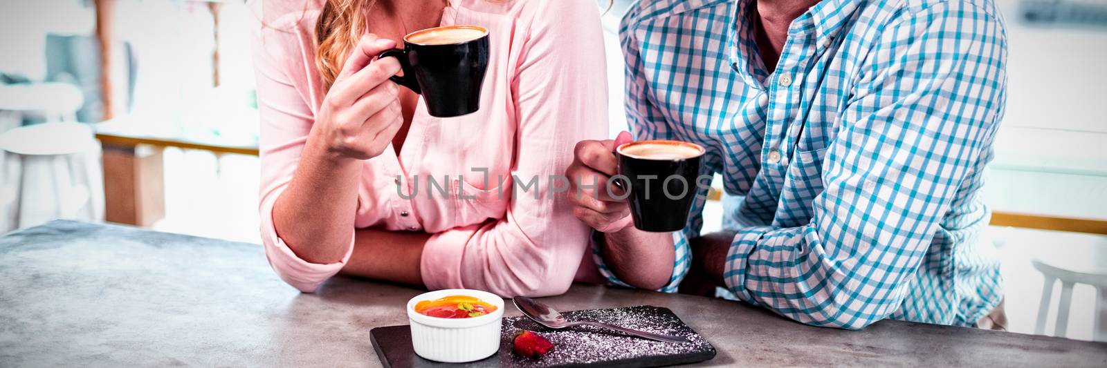 Happy couple having cup of coffee in cafe
