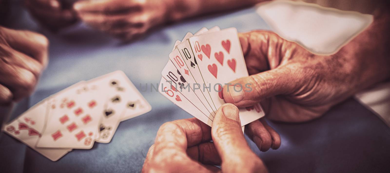 Group of seniors playing cards in the retirement house
