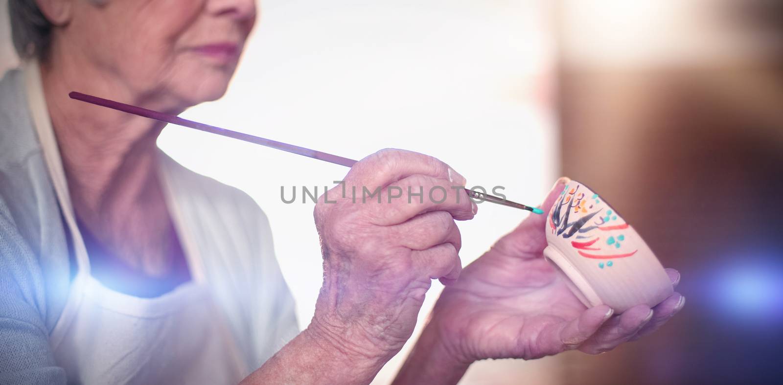 Close-up of female potter painting on bowl by Wavebreakmedia