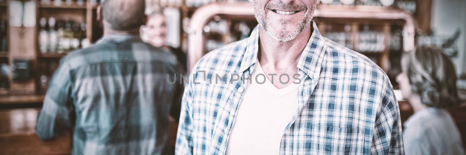 Portrait of happy man standing in bar