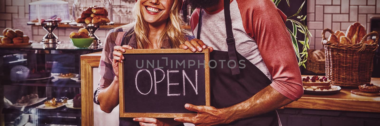 Waiter holding blackboard with open in the cafe