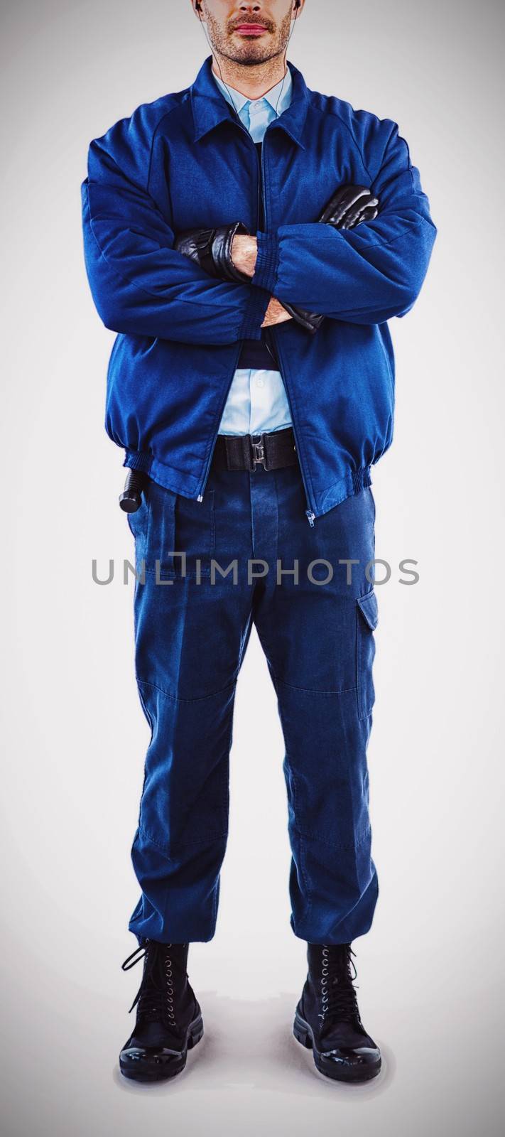 Portrait of security standing with arms crossed against white background