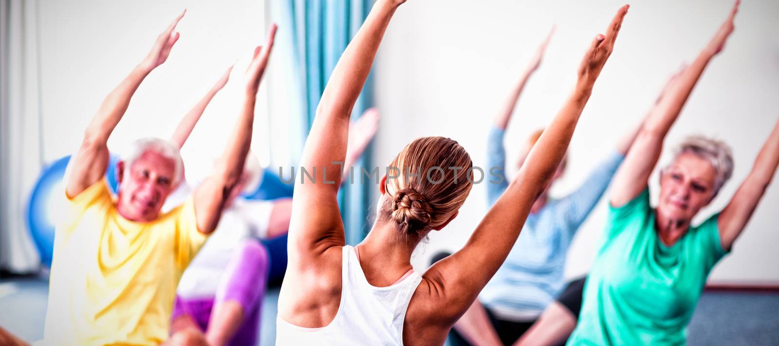 Instructor performing yoga with seniors during yoga class