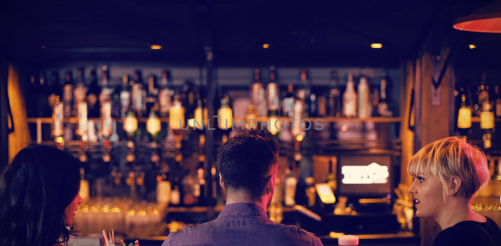 Friends enjoying the drinks at counter by Wavebreakmedia