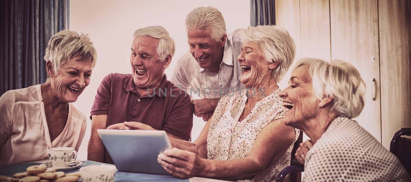 Group of seniors using digital tablet in the house
