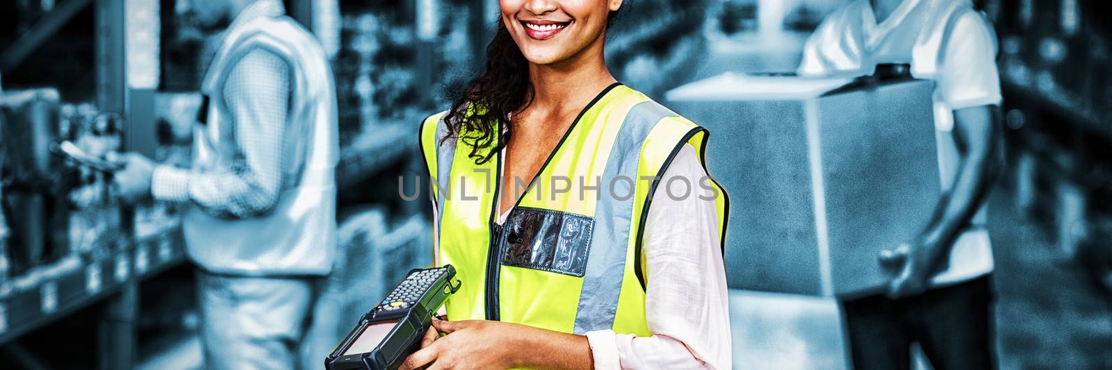 Portrait of female warehouse worker standing with barcode scanner in warehouse