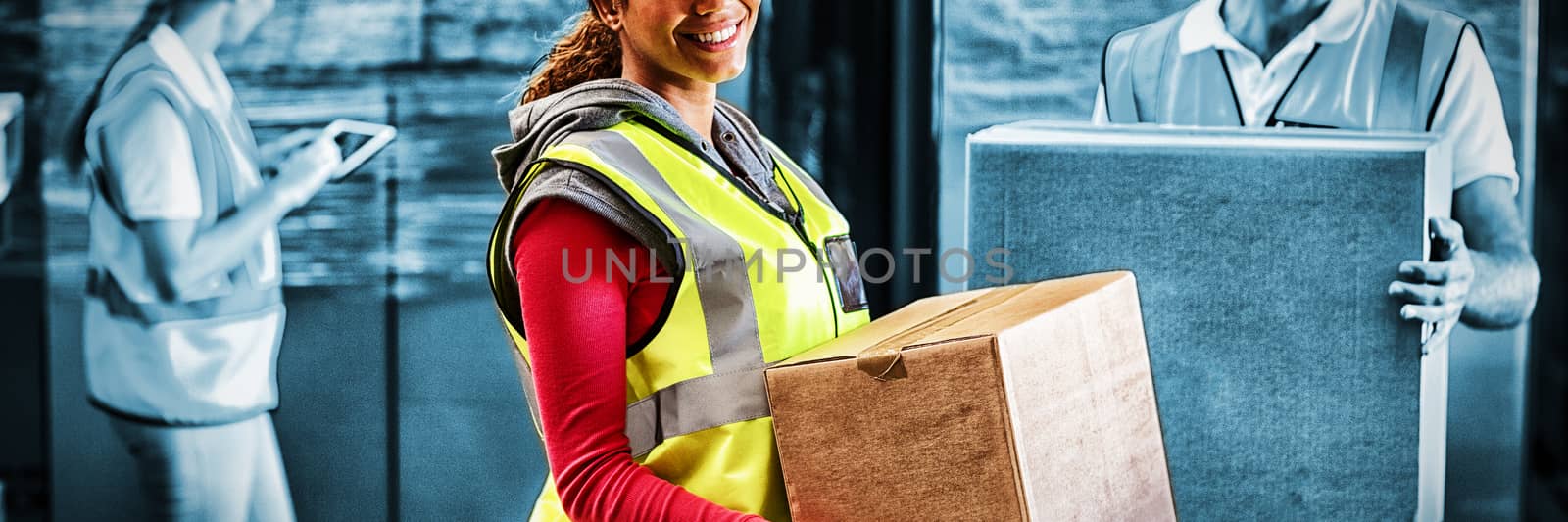 Worker is holding goods and smiling to the camera in a warehouse