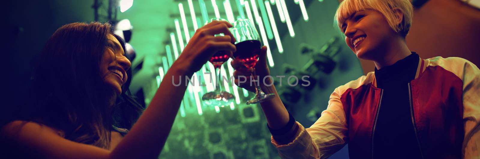 Friends toasting wine glasses in bar by Wavebreakmedia
