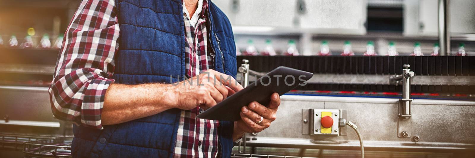 Portrait of smiling factory worker using digital tablet in the factory